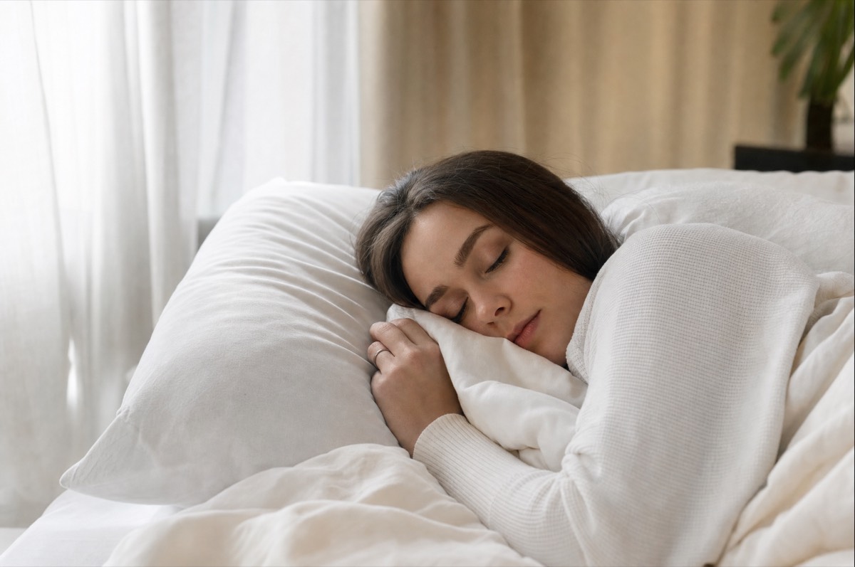 Person sleeping peacefully in a quiet bedroom insulated with sound-dampening spray foam